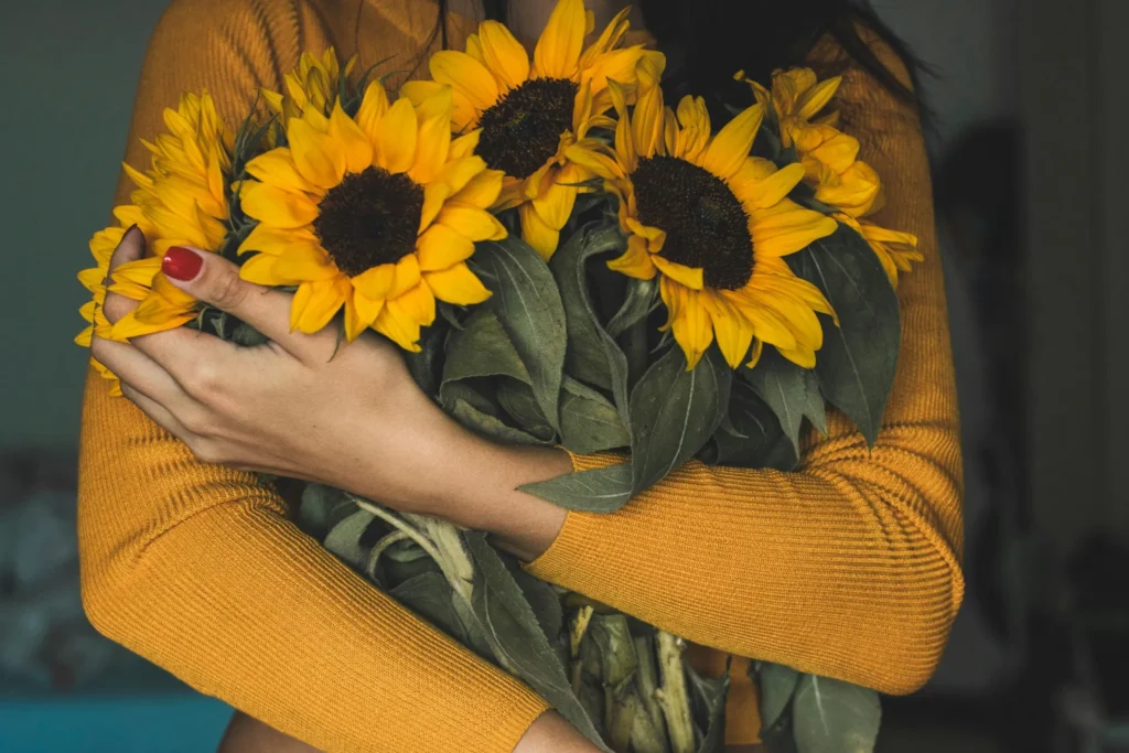 Mujer abrazando girasoles como símbolo de autoamor, elección personal y sanación emocional